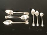 five spoons and two spoons sitting on a table