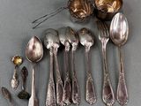 a lot of silver spoons and spoon spoons on the table