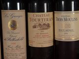 several bottles of wine are lined up in a row on a shelf
