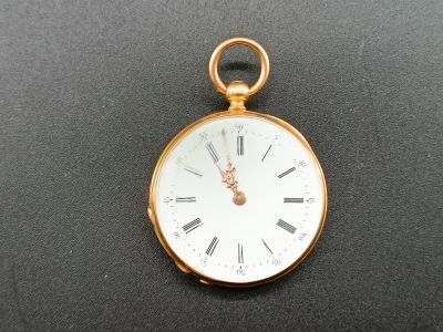 une montre de poche en or avec des chiffres romains sur le cadran