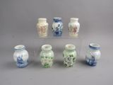 six vases aux motifs variés posés sur une table