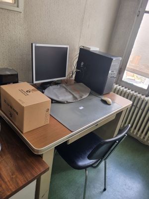 un bureau sur lequel se trouvent deux écrans d'ordinateur et une boîte