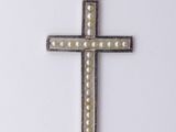 a close up of a cross on a white surface with pearls