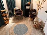 a living room with two chairs and a rug on the floor