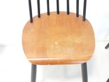 a wooden chair with black legs and a wooden seat