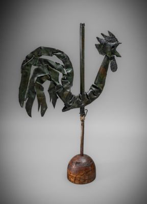 a close up of a statue of a rooster on a wooden base