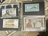 several different currency notes are in a binder on a table