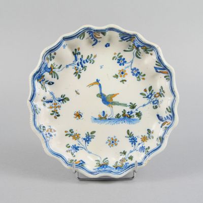 blue and white plate with a peacock and flowers on it