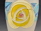 a white vase with a yellow rose painted on it