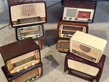 several old radio ' s are stacked on top of each other on the floor