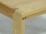 a close up of a wooden bench on a white floor