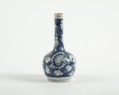 un vase bleu et blanc posé sur une surface blanche