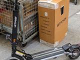 a scooter that is sitting next to a cart of boxes