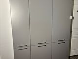 cabinets in a room with wood flooring and white walls