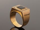 an image of a gold ring with a black stone and diamonds