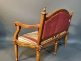 a small wooden chair with a red upholstered seat
