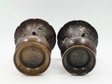 pair of antique bronze vases on a white background