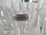 many wine glasses that are lined up on the table