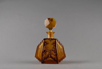 une petite bouteille en verre ornée d'un motif doré