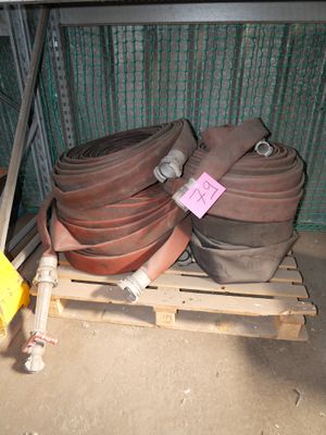 a pile of fire hoses on a pallet next to a fence