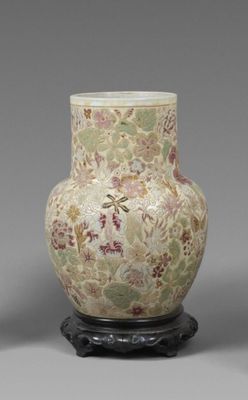 une paire de vases ornés de motifs floraux, posés sur un socle, sur fond gris