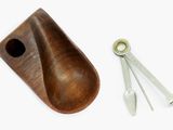 a wooden spoon and a pair of tongs on a white surface