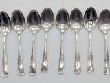 six silver spoons are lined up in a row on a table