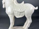 white ceramic horse figurine with a saddle on it ' s back