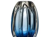 un vase en verre bleu avec un socle en argent, posé sur une surface blanche