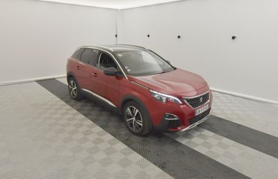 un SUV Nissan rouge garé dans un garage au sol carrelé