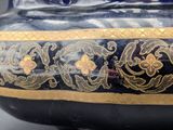 a black vase with gold designs on it