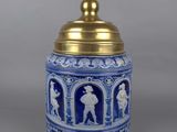 a close up of a blue and white vase with a gold lid