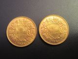 deux pièces d'or ornées d'un blason, posées sur une table