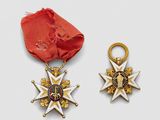 two medals and a red ribbon on a white surface