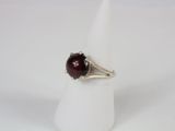 a close up of a ring with a red stone on it