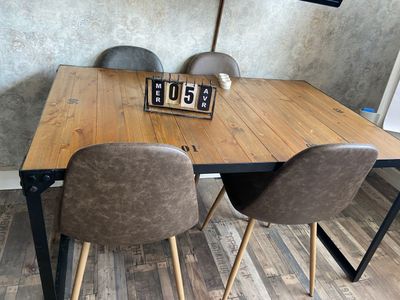 a wooden table with two chairs and a clock on it