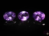 trois améthystes violettes posées sur une surface noire