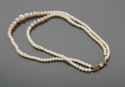 Un collier de deux rangs de perles d'imitation, le fermoir a…