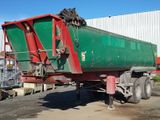 a green and red dump truck parked in front of a building