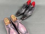 two pairs of men ' s shoes sitting next to each other on a table