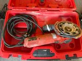 une boîte à outils rouge contenant une perceuse et d'autres outils