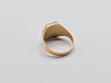 a close up of a gold ring on a white surface