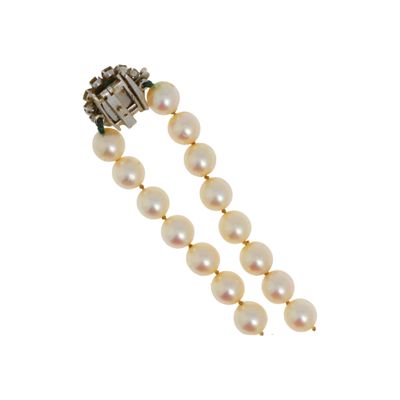 un gros plan sur un bracelet en perles muni d'un fermoir en diamant