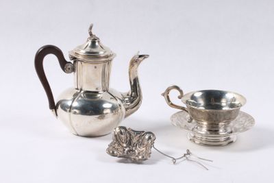 une théière en argent et une tasse en argent posées sur une table