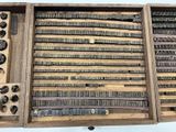 a wooden box filled with different types of typewriters