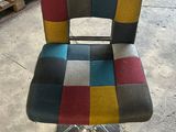 a chair that has a colorful seat on it in a warehouse