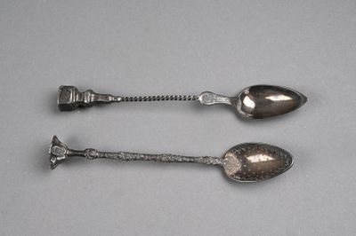 une paire de cuillères en argent posées sur un support gris, avec un manche en argent