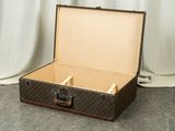 a suitcase that is sitting on the floor with a white curtain in the background