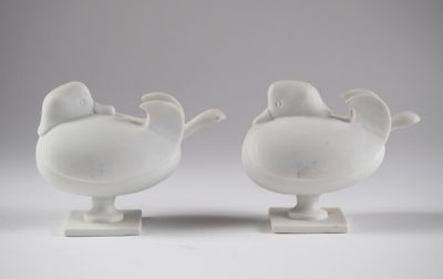paire de vases en porcelaine blanche ornés d'oiseaux, posés sur des socles, sur un fond blanc
