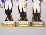 two figurines of men dressed in military uniforms stand next to each other